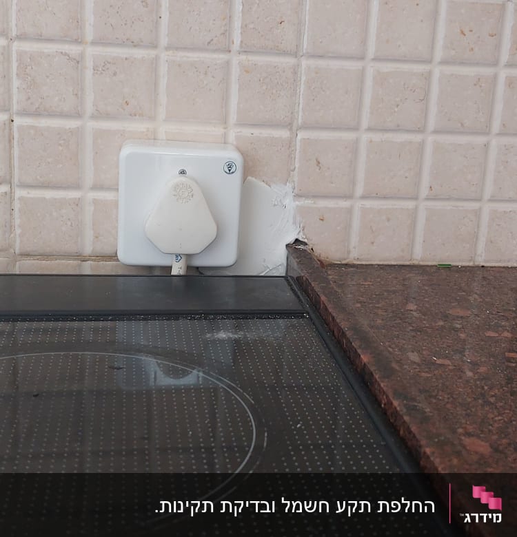 שקע חשמלי עם תקע על קיר מטבח